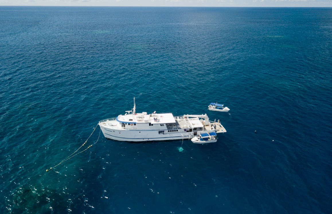 Aerial view of expedition vessel anchored in pristine blue waters